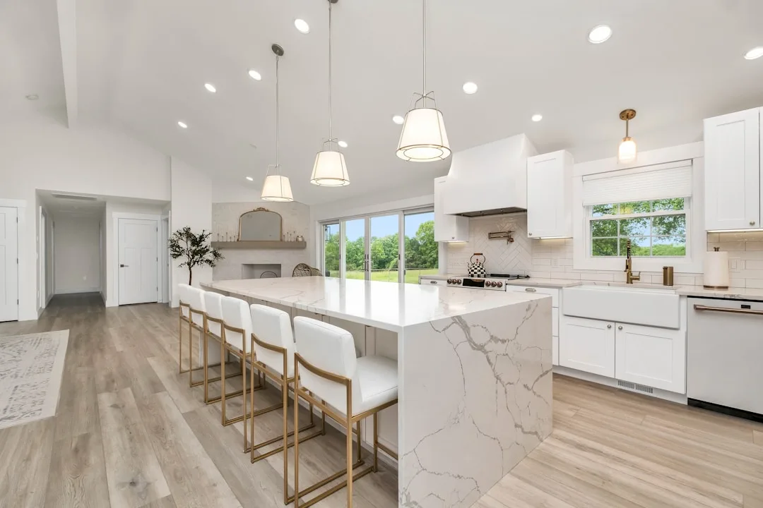 Nhà bếp hiện đại hoàn chỉnh với tủ trắng và đảo bếp đá marble