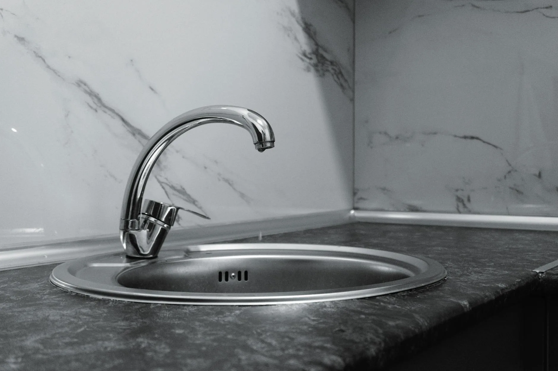 Vòi bếp chrome đang chảy nước trong không gian bếp sạch sẽ